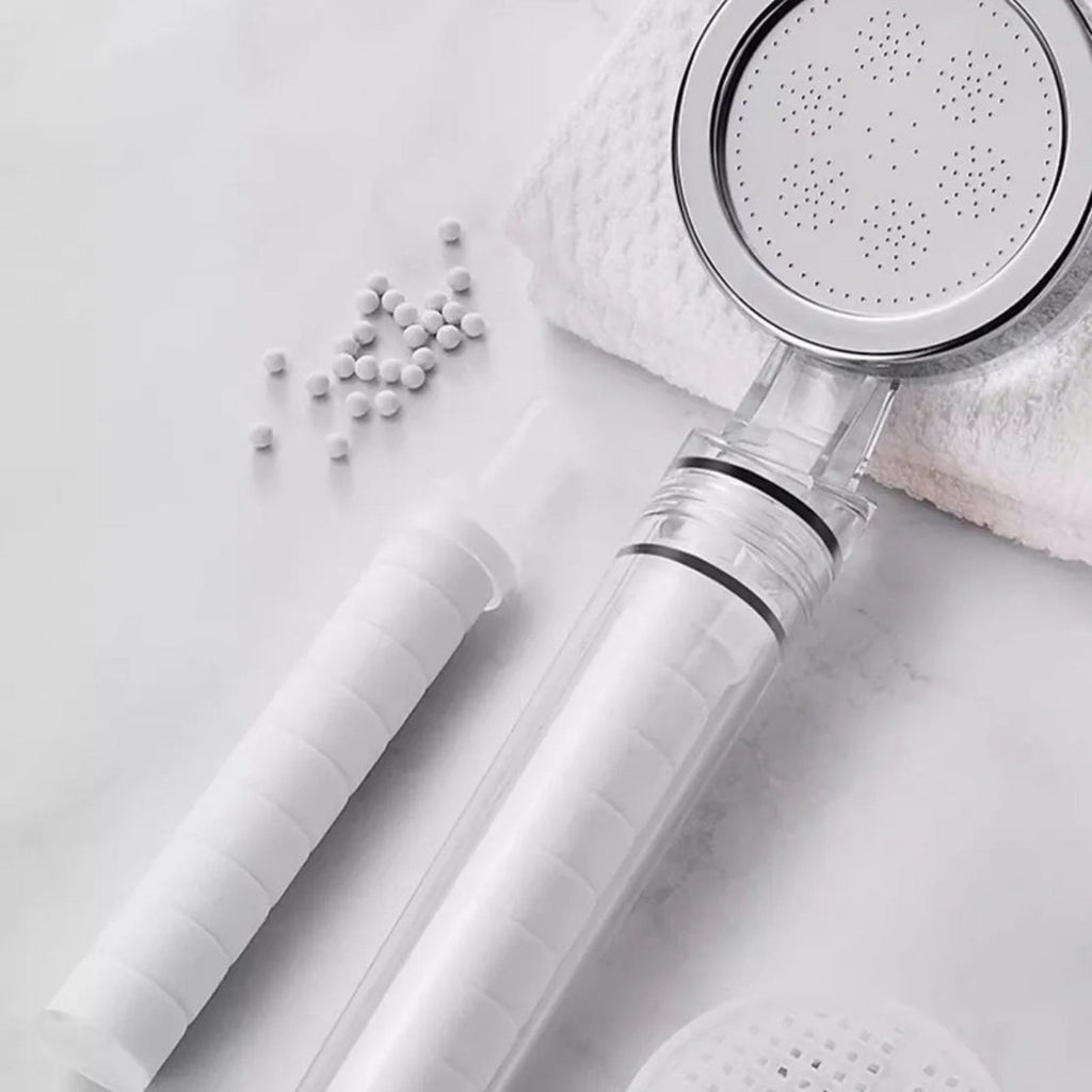 Pommeau filtrant Nevya et billes filtrantes dans une salle de bain