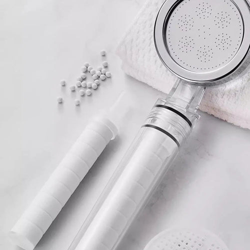 Pommeau filtrant Nevya et billes filtrantes dans une salle de bain